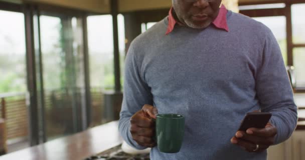 Afro Americano Sênior Balcão Cozinha Usando Smartphone Beber Café Estilo — Vídeo de Stock