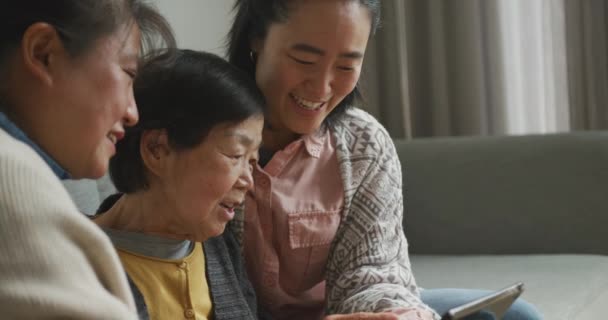 快乐的年长的亚洲母亲 成年的女儿和孙女在客厅里用平板电脑和笑声 退休生活 快乐的家庭一起在家里度过美好时光 — 图库视频影像