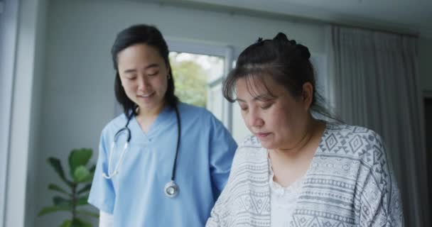 Улыбающаяся Азиатка Врач Помогает Счастливой Пациентке Ходить Ходячей Рамой Больнице — стоковое видео