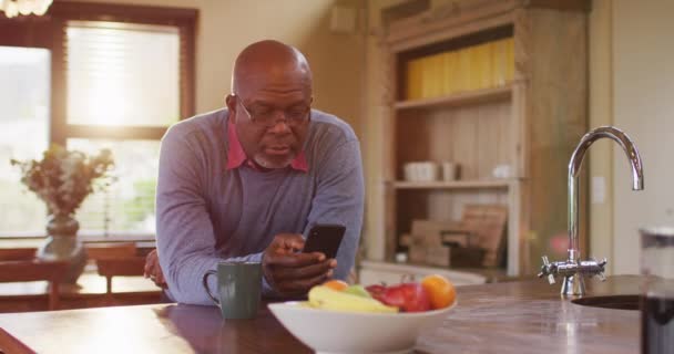 Afroameričan Starší Muž Opírající Kuchyňský Pult Pomocí Smartphonu Usmívající Důchodový — Stock video