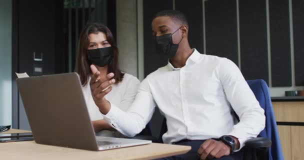 不同的商人和女商人都戴着口罩 在办公室讨论和使用笔记本电脑 危机期间在位的商界和商界人士19 — 图库视频影像