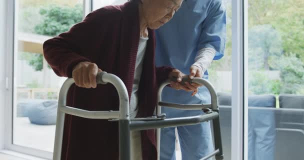 Smiling Asian Female Doctor Helping Senior Female Patient Walk Using — Stock Video