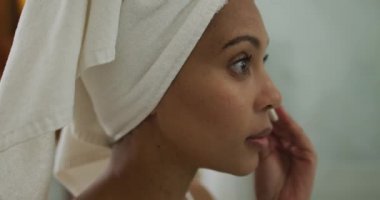 Karışık ırktan bir kadın kafasını havluyla temizliyor. ev hayatı, kaliteli boş zaman geçirmek evde dinlenmek..