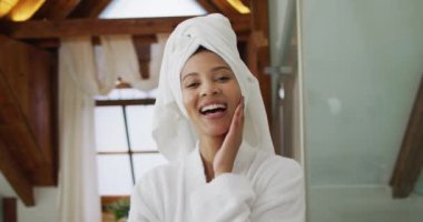 Kameraya bakan bornoz giymiş melez bir kadının portresi. ev hayatı, kaliteli boş zaman geçirmek evde dinlenmek..