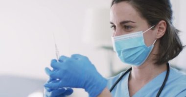 Kafkasyalı kadın doktor evde yüz maskesi takıp aşı yaptırıyor. Coronavirus covid 19 salgını sırasında ilaç, sağlık ve sağlık hizmetleri.