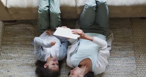 Šťastný Smíšený Závod Matka Dcera Ležící Podlaze Baví Pomocí Tabletu — Stock video