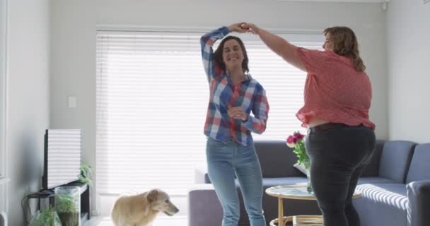 白人レズビアンのカップルは犬と踊って笑顔 家庭でリラックスしながら自由な時間を過ごす国内生活 — ストック動画