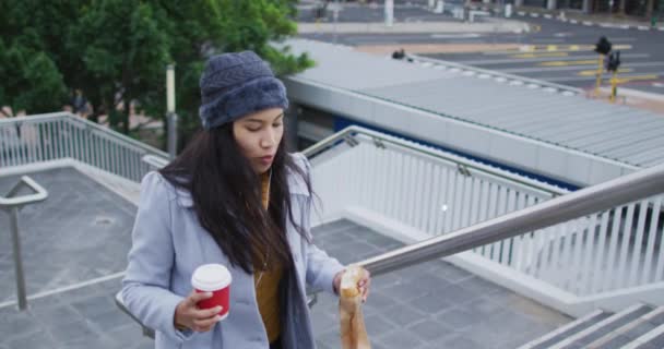 Mujer Asiática Caminando Sosteniendo Café Para Llevar Comiendo Sándwich Nómada — Vídeos de Stock