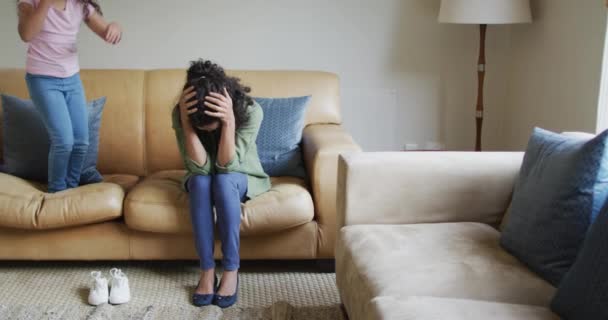 Filha Raça Mista Pulando Sofá Mãe Está Estressada Vida Doméstica — Vídeo de Stock