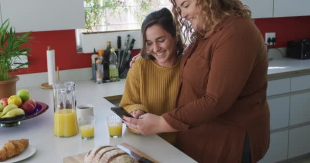 Glad Kaukasiska Lesbiska Par Omfamna Och Använda Smartphone Köket Hushållsliv — Stockvideo