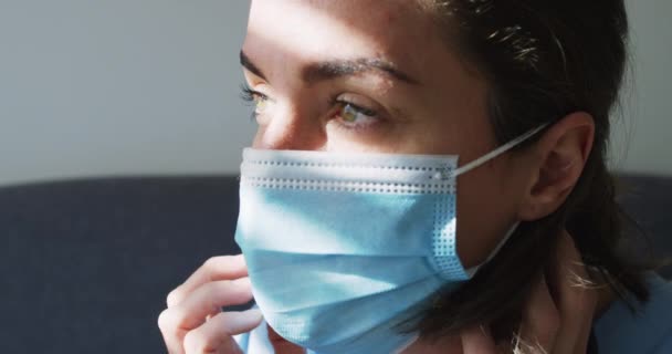 ソファに腰を下ろして顔のマスクをした白人女性医師 コロナウイルスにおける医療 医療サービス Covid 19パンデミック — ストック動画