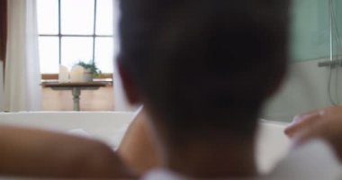 Karışık ırktan bir kadın banyo yapıyor. ev hayatı, kaliteli boş zaman geçirmek evde dinlenmek..