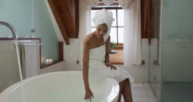 Küvet işleten melez bir kadın. ev hayatı, kaliteli boş zaman geçirmek evde dinlenmek..