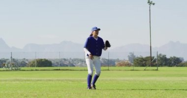 Beyaz kadın beysbol oyuncusu, saha atlayıcısı, beyzbol sahasında top yakalama ve atma. Kadın beyzbol takımı, spor antrenmanı ve oyun taktikleri.