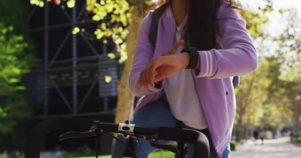 園内の自転車に座っている間 スマートウォッチを使っているアジアの女性 現代のライフスタイルと生活コンセプト — ストック動画
