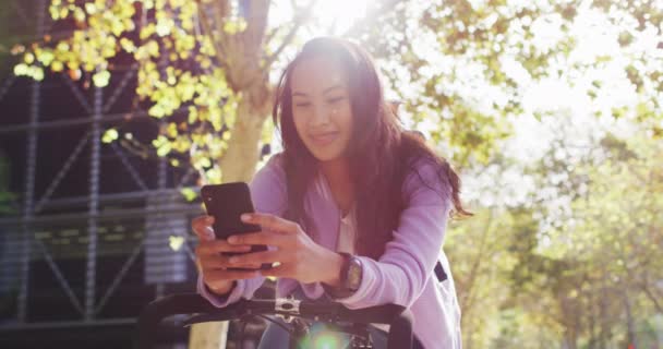 Asiatisk Kvinna Med Cykel Leende När Använder Smartphone Parken Modern — Stockvideo