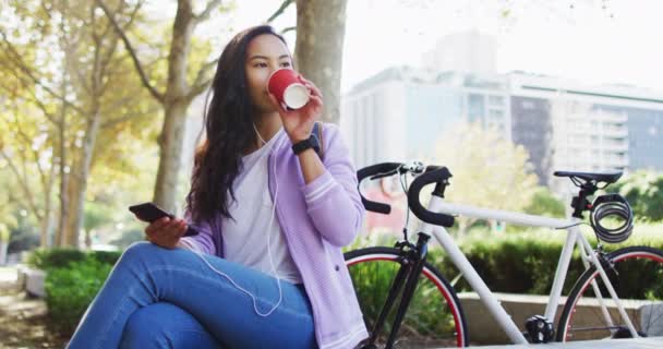 Donna Asiatica Con Gli Auricolari Che Ascolta Musica Beve Caffè — Video Stock