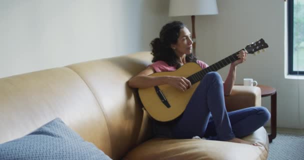 Щаслива Змішана Жінка Яка Сидить Дивані Граючи Гітарою Концепція Домашнього — стокове відео