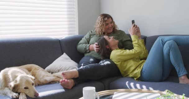 레즈비언 커플이 소파에 앉아서 에서의 집에서의 — 비디오