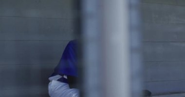 Sinirli melez bayan beyzbol oyuncusu, yedek kulübesinde oturuyor, elinde beysbol topu tutuyor. Kadın beyzbol takımı, spor antrenmanı ve oyun taktikleri.