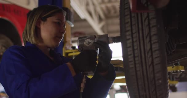 Kobieta Mechanik Zmieniając Opony Samochodu Pomocą Wiertarki Stacji Paliw Samochodu — Wideo stockowe