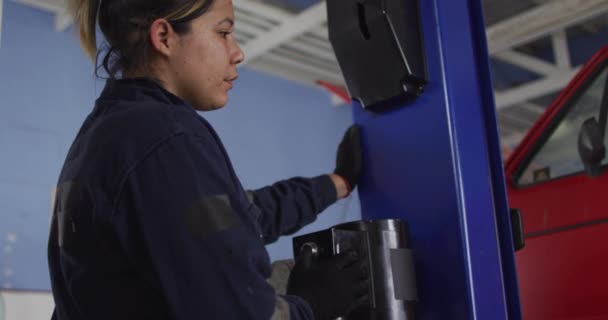 Женщина Механик Поднимает Автомобиль Помощью Автоматического Крана Нажав Кнопку Автосервисе — стоковое видео