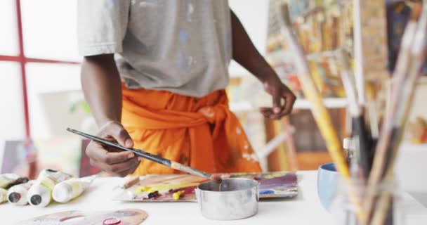 アフリカ系アメリカ人の男性画家の絵画の中央部は アーティストスタジオでキャンバス上 芸術的創造的余暇的時間概念 — ストック動画