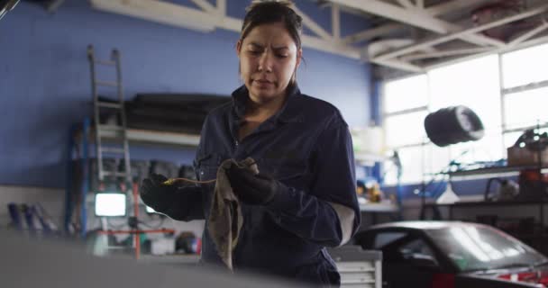 女性の整備士は 車のサービスステーションで布で車の清掃機器 自動車修理サービス — ストック動画