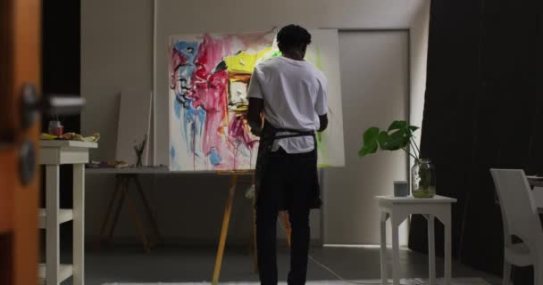 非洲裔美国男性艺术家穿着围裙在画布上在艺术工作室的后视镜 业余爱好和创造性职业概念 — 图库视频影像