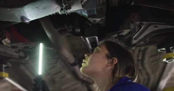 Mecánica Femenina Usando Una Lámpara Led Trabajando Debajo Coche Una — Vídeo de stock