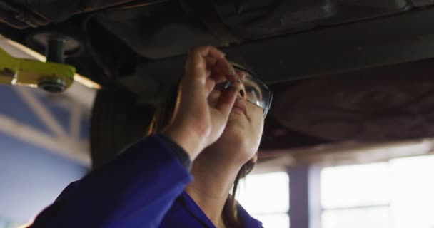 Mecânico Feminino Usando Óculos Proteção Inspecionando Carro Uma Estação Serviço — Vídeo de Stock