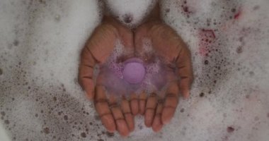Afro-Amerikan çekici kadının elleri köpük, tuz ve gül yapraklarıyla banyo yapıyor. güzellik, şımartma, spa ve refah konsepti.