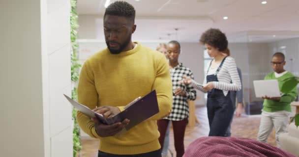 Hombre Negocios Creativo Afroamericano Sosteniendo Documentos Caminando Oficina Moderna Entorno — Vídeos de Stock