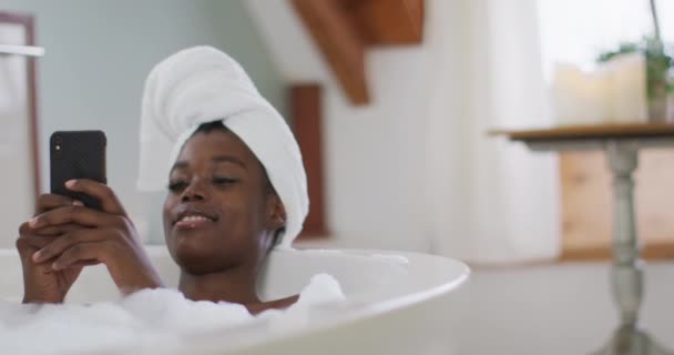 Sorrindo Afro Americana Atraente Mulher Relaxante Banheira Usando Smartphone Banheiro — Vídeo de Stock