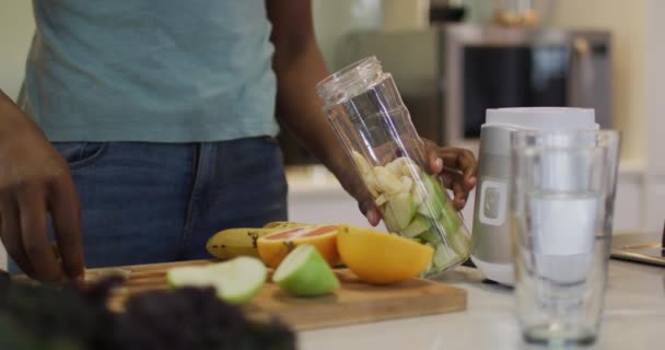 Gülümseyen Afrikalı Amerikalı Çekici Bir Kadının Mutfakta Smoothie Hazırlamasının Ortasında — Stok video
