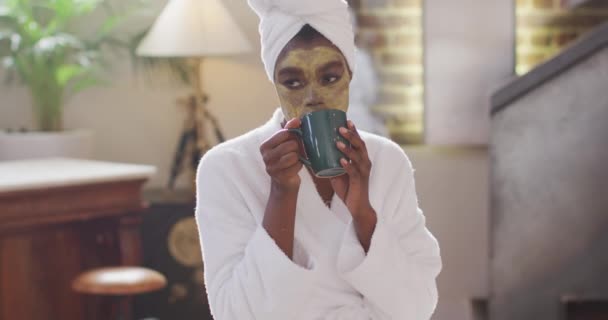 Afro Amerikaanse Aantrekkelijke Vrouw Met Toegepast Gezichtsmasker Drinken Van Koffie — Stockvideo