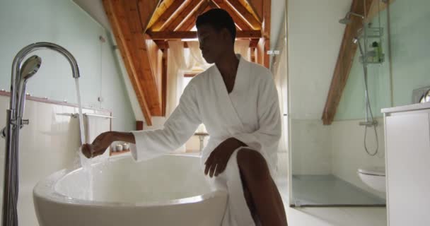 Mujer Atractiva Afroamericana Sonriente Bata Blanca Sentada Bañera Preparando Baño — Vídeos de Stock