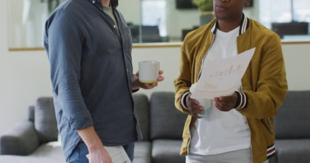 Dos Colegas Masculinos Diversos Mirando Gráficos Teniendo Conversaciones Negocios Oficina — Vídeos de Stock