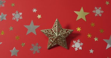 Yıldızlı Noel süslemeleri ve kırmızı arka planda kar desenleri. Noel, gelenek ve kutlama konsepti.