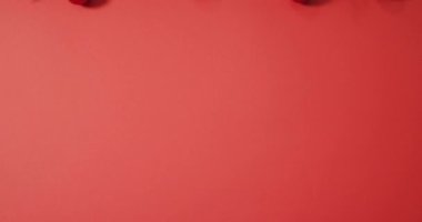 Noel süslemeleri, takılar ve kırmızı arka planda kopyalama alanı. Noel, gelenek ve kutlama konsepti videosu.