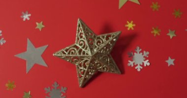 Yıldızlı Noel süslemeleri ve kırmızı arka planda kar desenleri. Noel, gelenek ve kutlama konsepti.