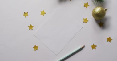 Beyaz arka planda beyaz kartı olan noel süslemeleri ve yıldızların videosu. Noel, gelenek ve kutlama konsepti.