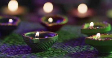 Dekoratif kil kaplarda mumlar örülmüş masa örtüsünde, ön planda odaklanmış, arka planda bokeh. diwali festivali, kutlama, gelenek ve tören konsepti.