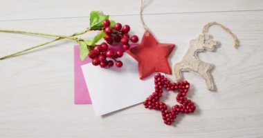 Noel süslemelerinin videosu, beyaz ve pembe kartlı kırmızı böğürtlenler ahşap arka planda. Noel, gelenek ve kutlama konsepti.