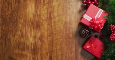 Hediyeli Noel süslerinin videosu ve ahşap arka planda fotokopi alanı. Noel, gelenek ve kutlama konsepti.