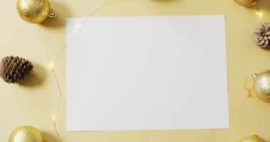 Sarı arka planda beyaz kağıtlı Noel süslerinin videosu. Noel, gelenek ve kutlama konsepti.