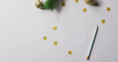 Beyaz arka planda beyaz kartı olan Noel süslerinin videosu. Noel, gelenek ve kutlama konsepti.