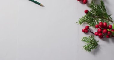 Beyaz kartlı kırmızı böğürtlenli Noel süslemeleri ve beyaz arka planda fotokopi alanı. Noel, gelenek ve kutlama konsepti.