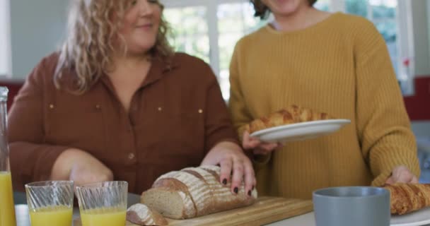 快乐的高加索女同性恋夫妇在厨房切面包和准备食物 家庭生活方式 在家里消磨时光 — 图库视频影像