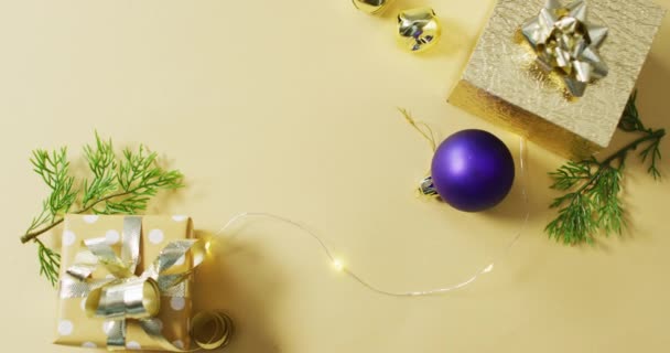 金と紫のクリスマスの装飾のビデオと黄色の背景に提示します クリスマス お祝いのコンセプト — ストック動画